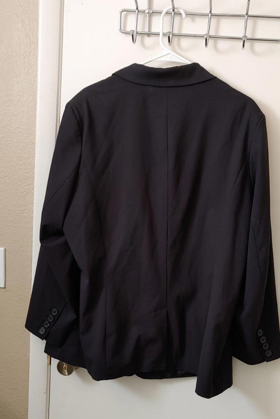 Black blazer back view with full-length sleeves and center back seam.