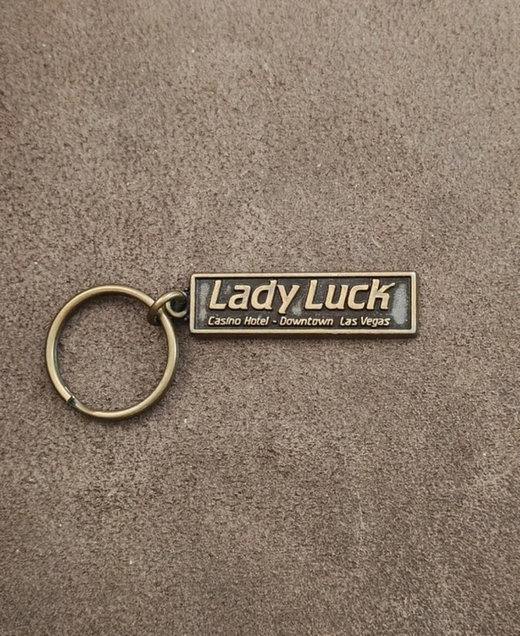 Gold Lady Luck casino hotel keychain with rectangular engraved tag and key ring