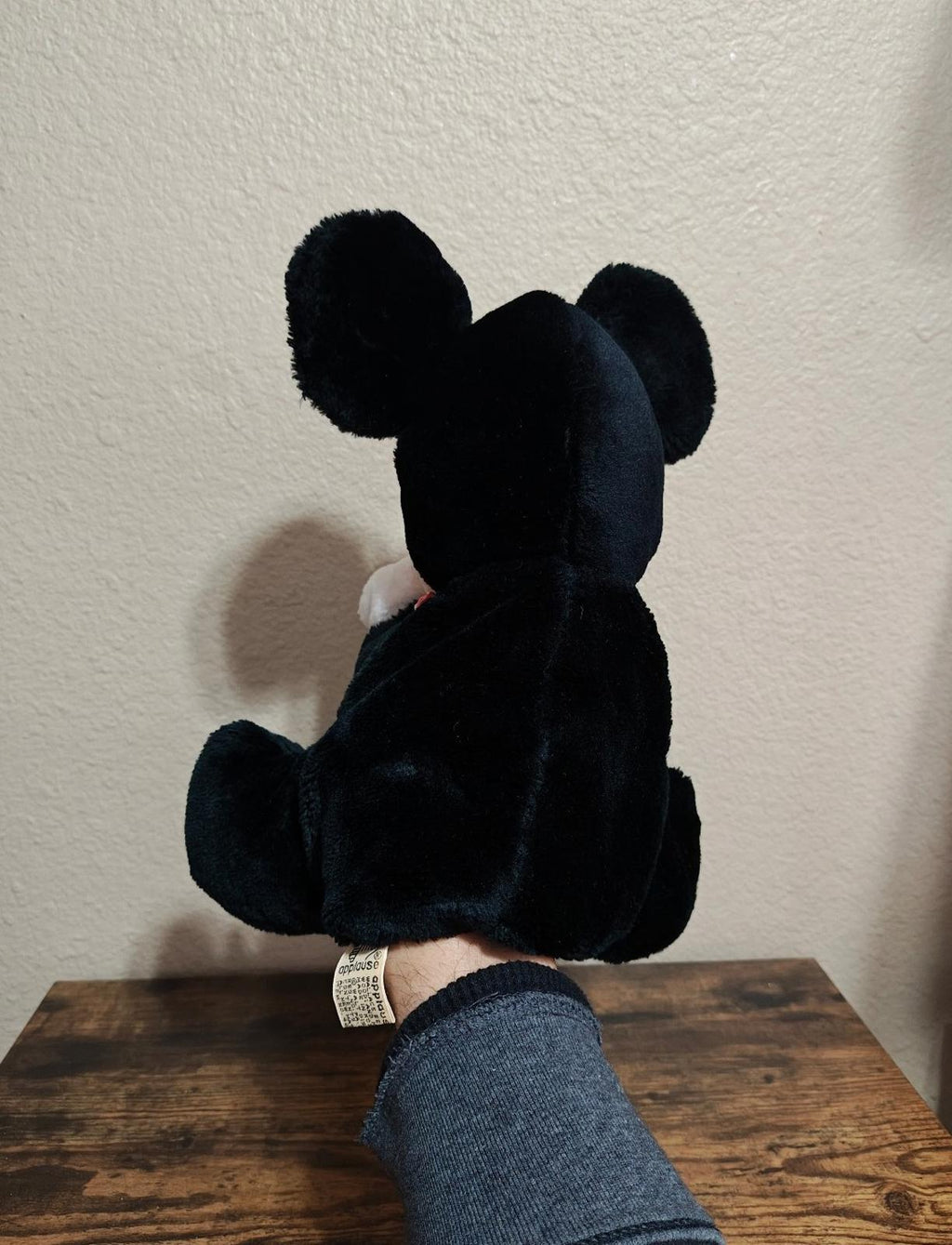 Back view of black plush Mickey Mouse hand puppet with bow tie detail