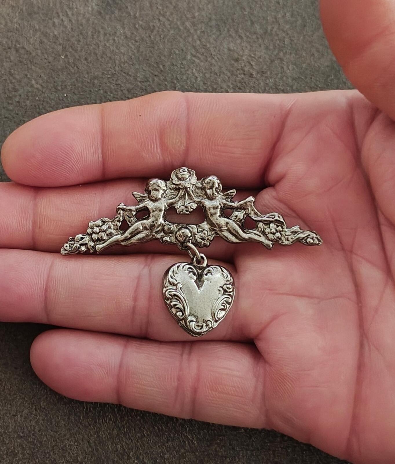 1980s Silver Tone Renaissance Style Cherub Brooch With Dangling Heart Charm