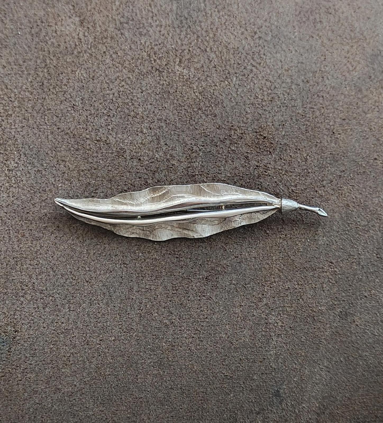 Silver leaf brooch shown from above, hammered texture and slender pin stem