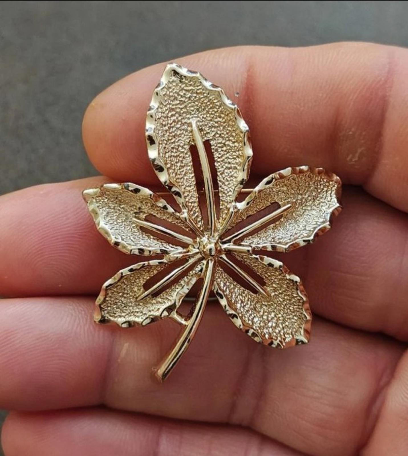 Gold-tone leaf brooch with five-point flower design and raised detail, vintage style