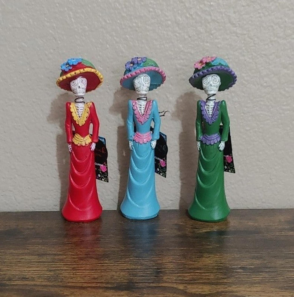 Set of three Day of the Dead lady figurines in red, blue, and green dresses, standing