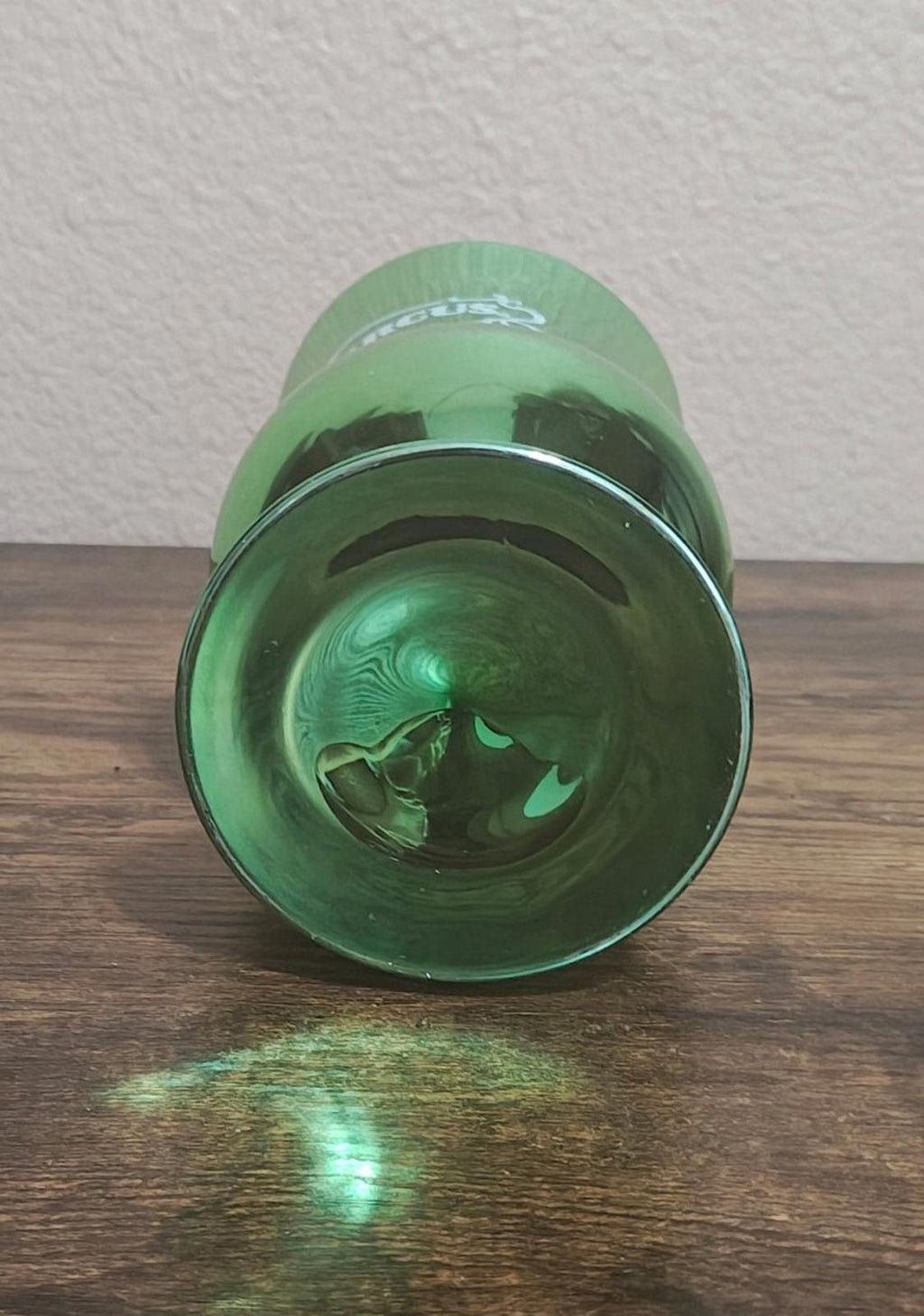 Green mirrored hurricane glass interior base view with circular design and reflection.