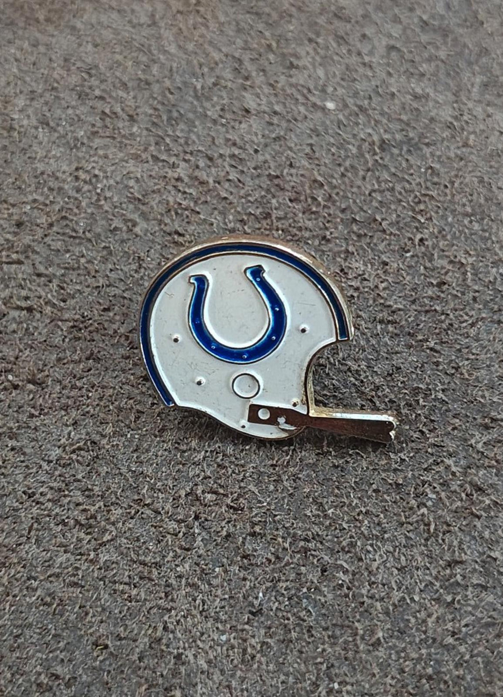 Gold-tone enamel tie clip close-up of white helmet and blue horseshoe detail