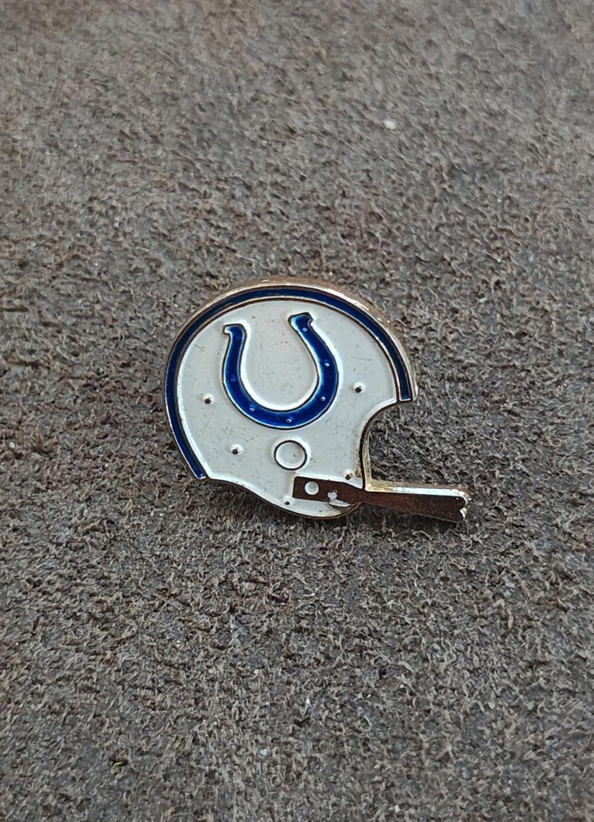 Gold-tone enamel tie clip close-up of white helmet and blue horseshoe detail