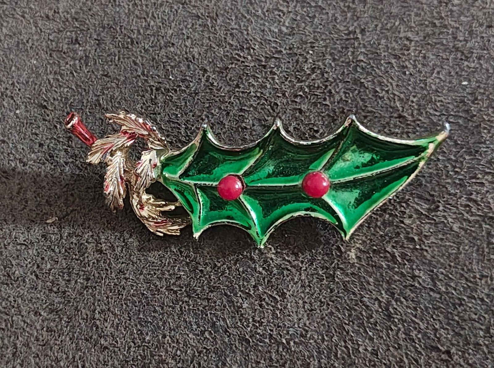 Green holly enamel brooch with gold tone leaves and two centered red berries.