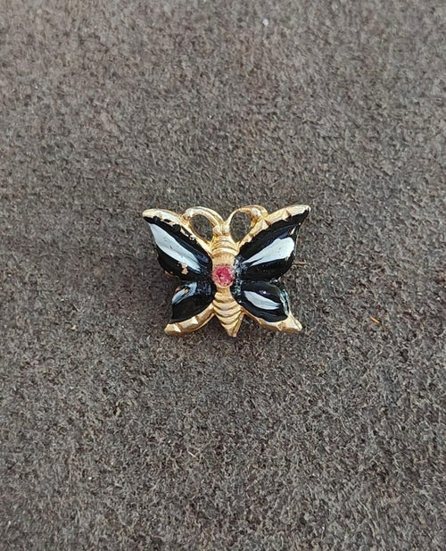 Gold-tone butterfly brooch with black enamel wings, blue inlays, red center