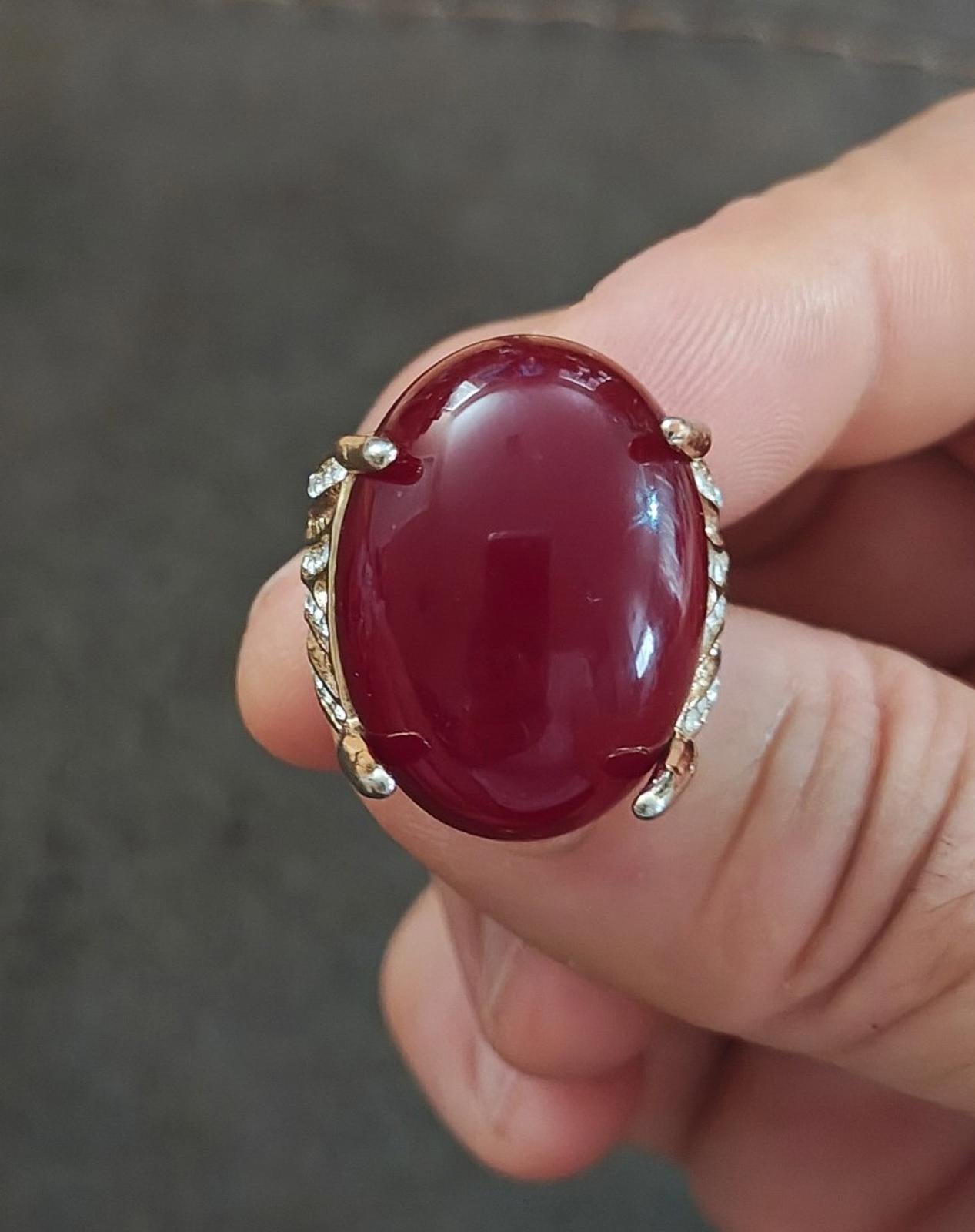 Red oval faux stone ring with gold-tone prongs and small clear rhinestones