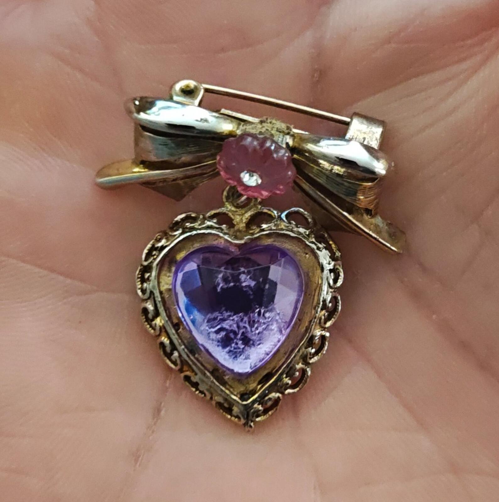 Gold-tone heart brooch with purple stone heart, filigree frame, pink flower bow detail
