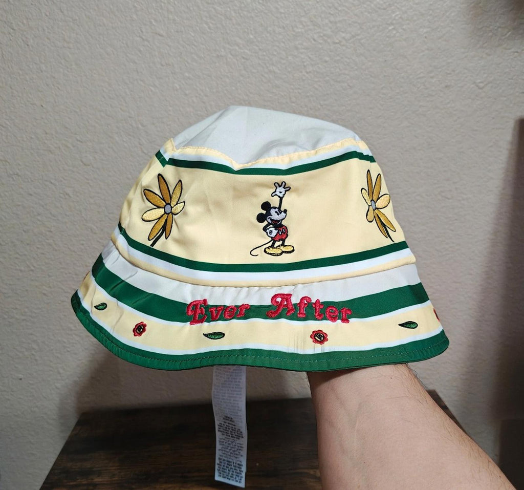 Cream bucket hat with green stripes, Mickey Mouse patch, “Ever After” graphic, flower accents