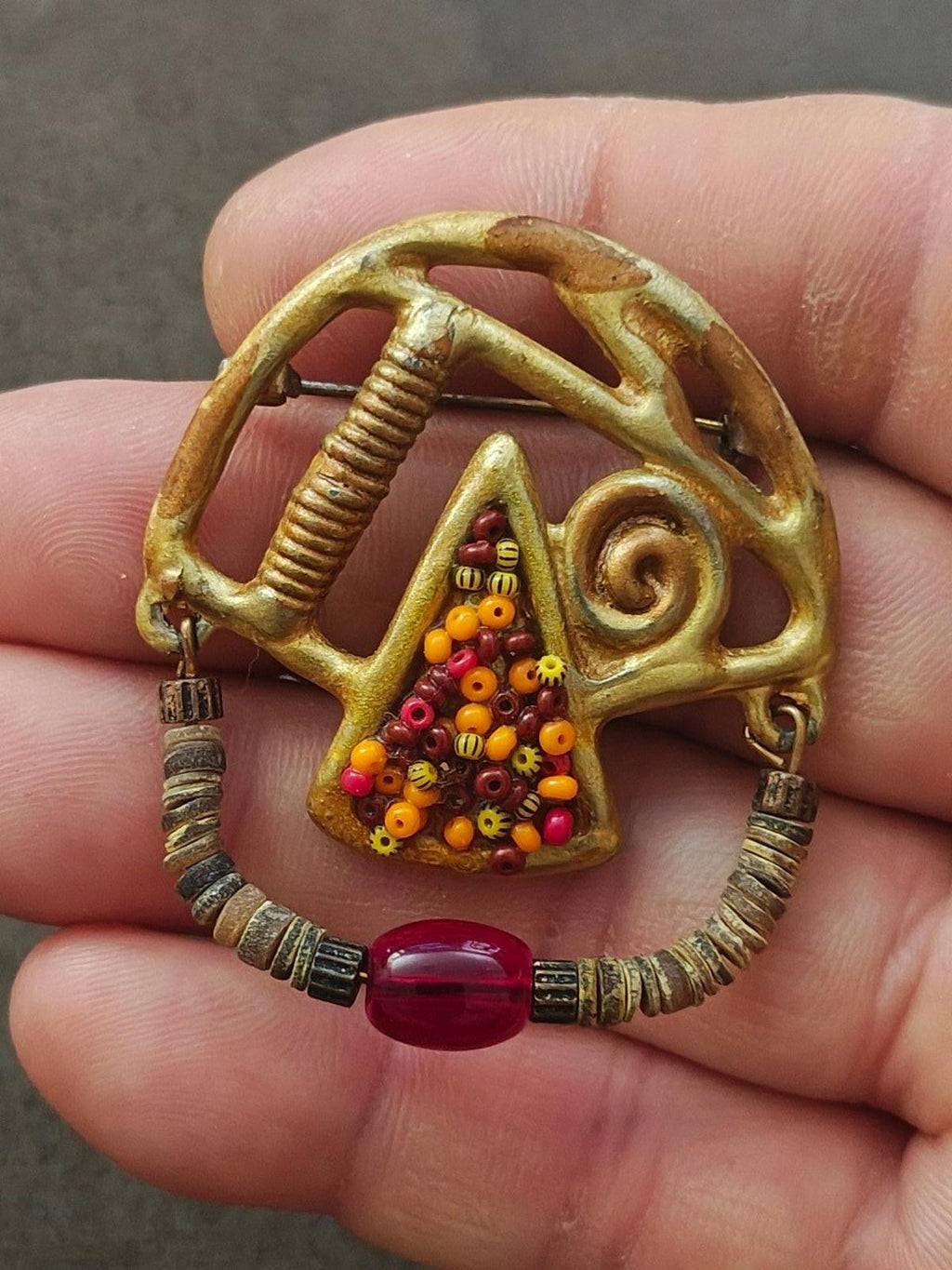 Gold-tone abstract beaded brooch with triangle beadwork and red cabochon center