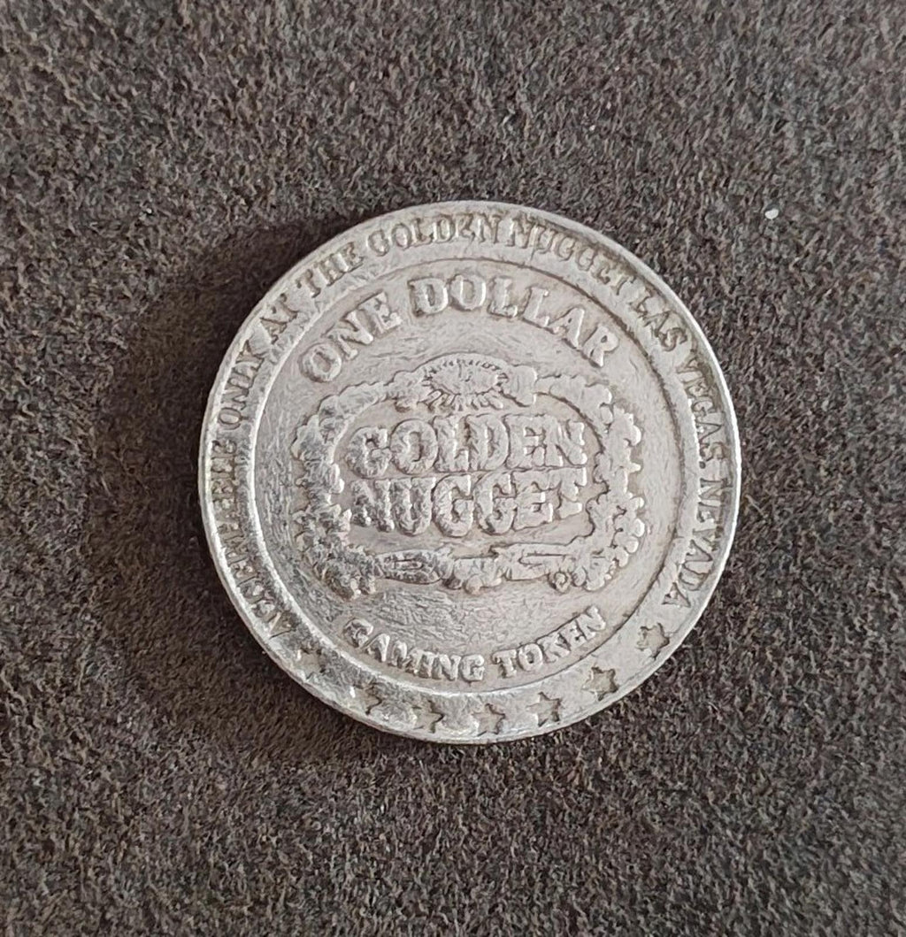 Silver Golden Nugget one-dollar token reverse, showing GOLDEN NUGGET and COMING TOKEN.