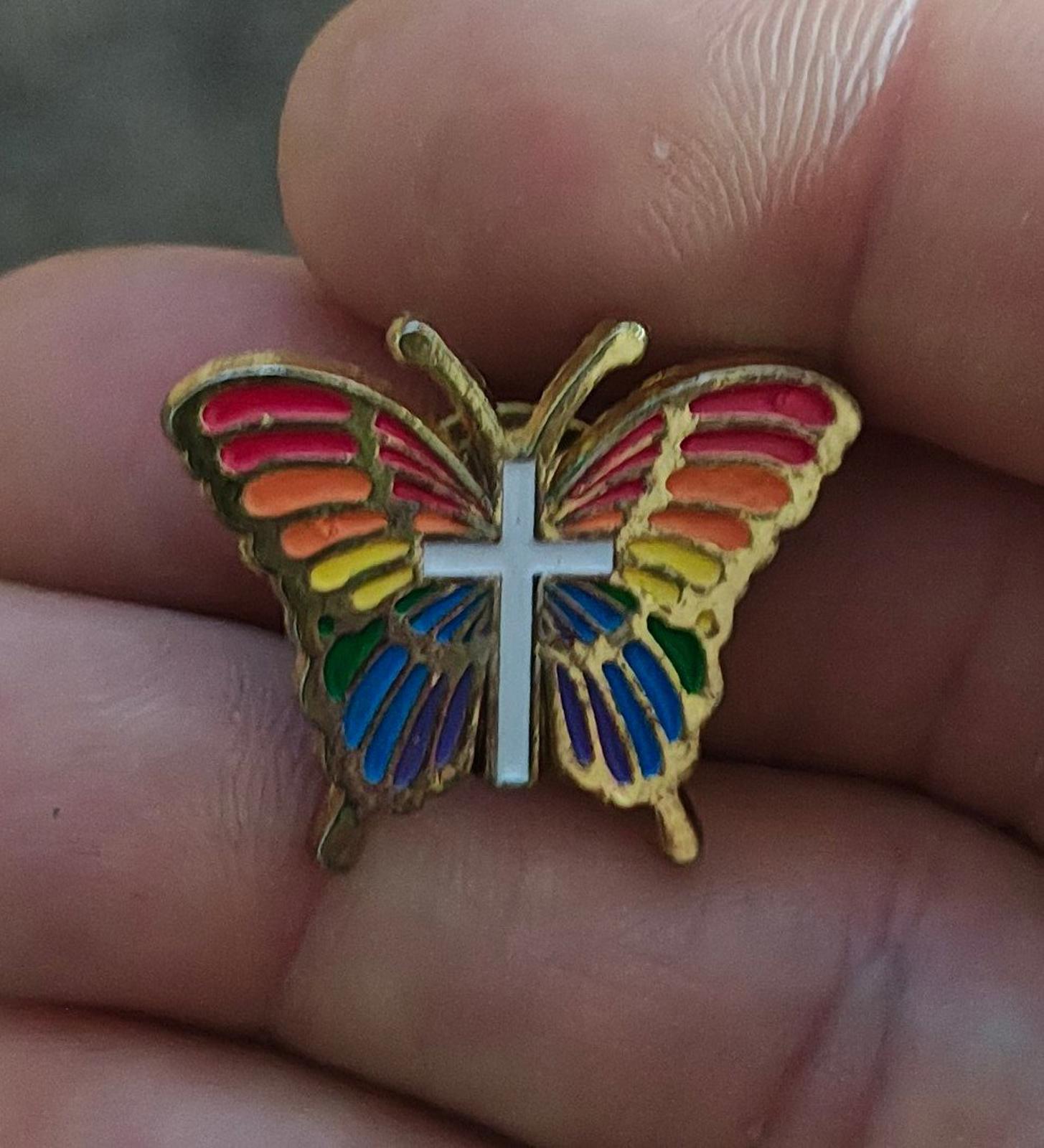 Rainbow butterfly enamel pin with white cross, gold-tone frame