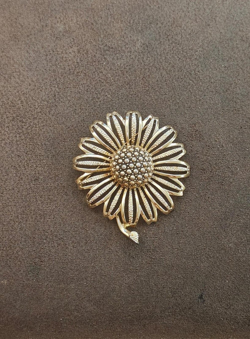 Gold tone daisy-style sunflower brooch with rhinestone center and scalloped petal rays