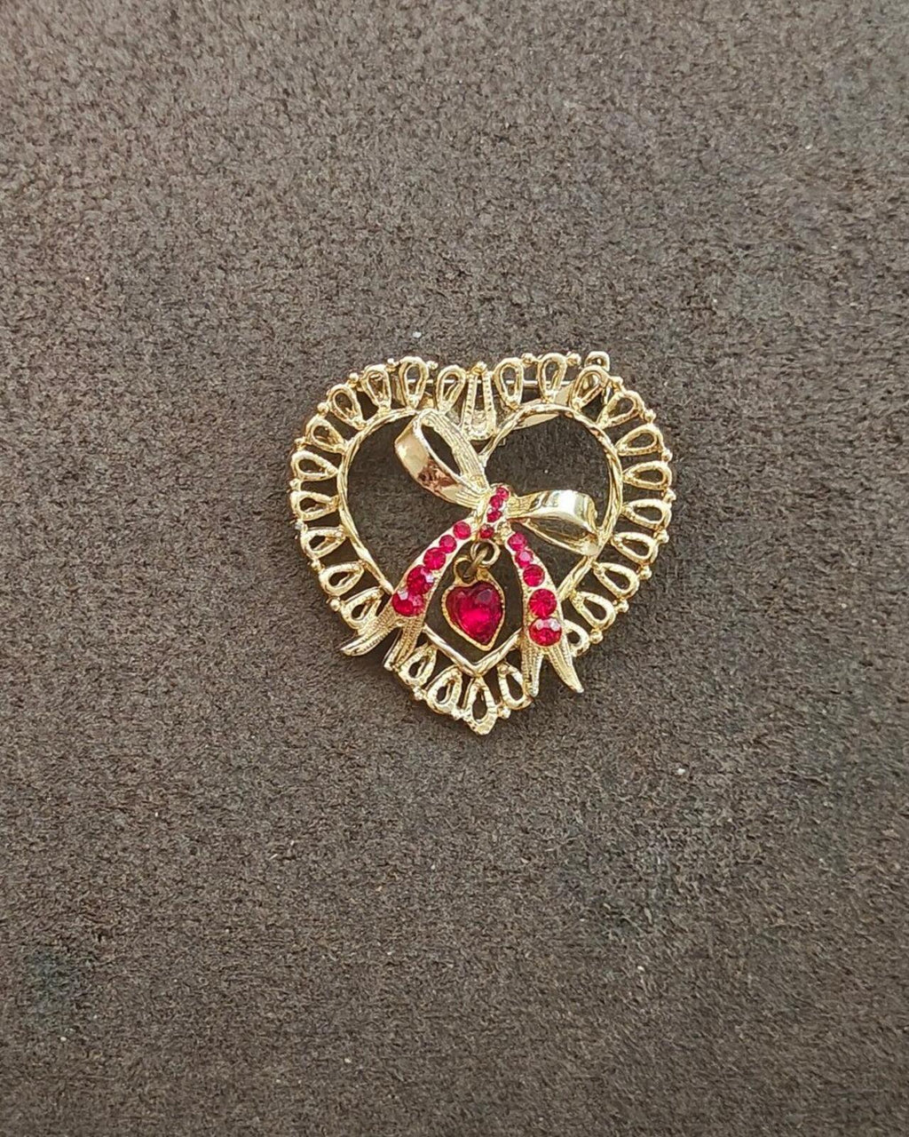 Gold tone heart brooch with red rhinestone center bow and heart drop