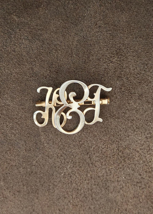 Gold-tone monogram brooch pin, stylized KEG initials in ornate openwork