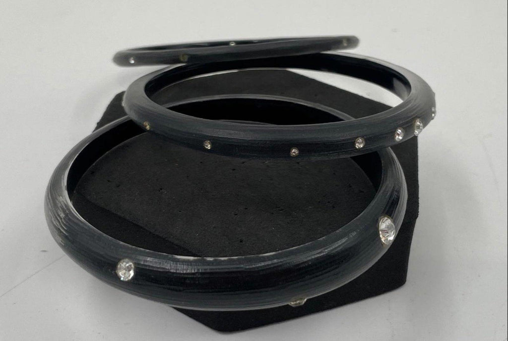 Black lucite bangle set with crystal studs around the bracelet edges