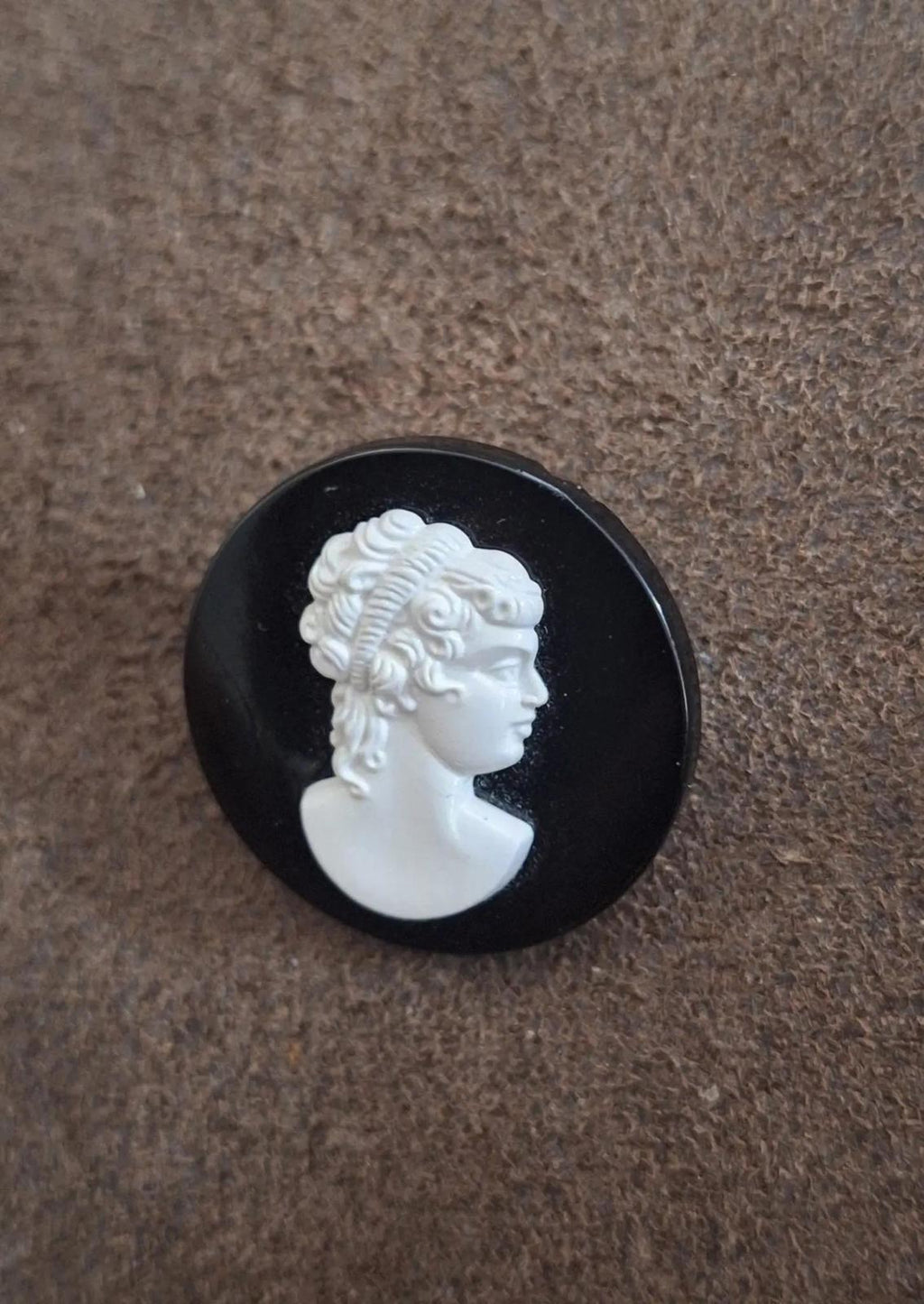 Black round cameo brooch with white woman profile head relief