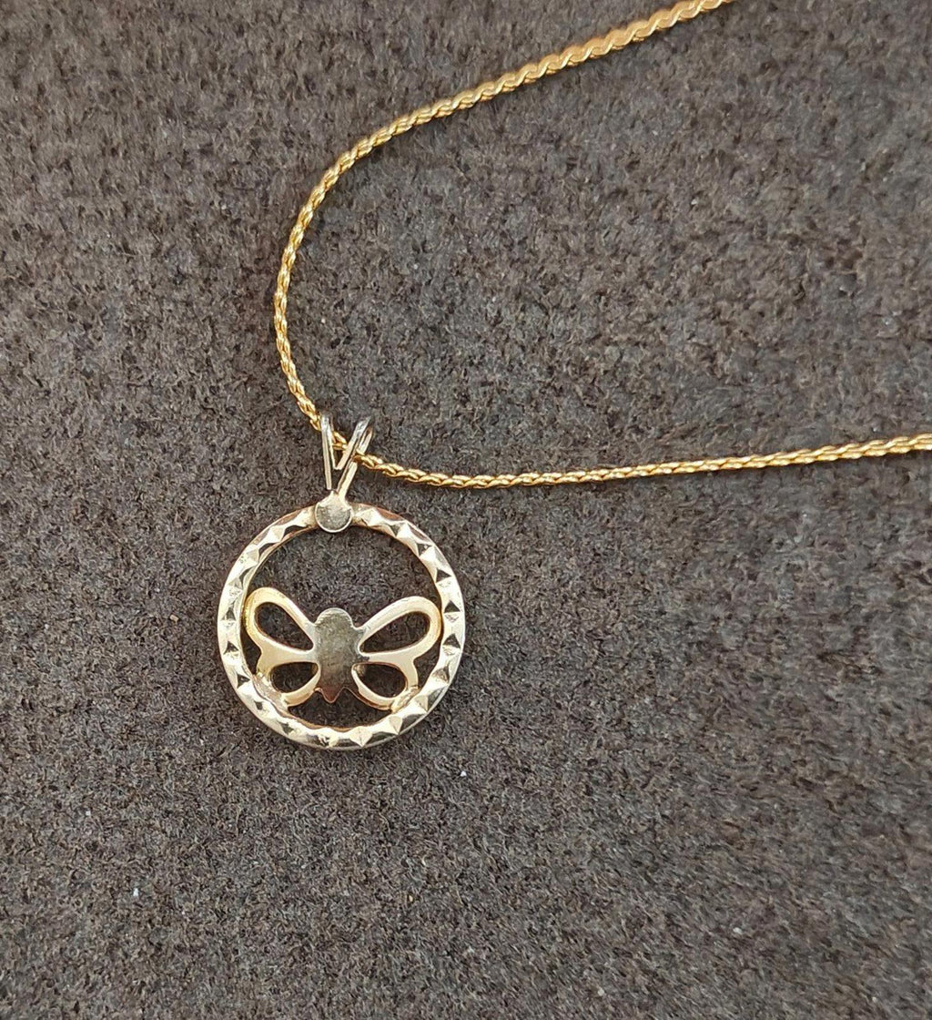 Gold-tone pendant necklace close-up: round open circle with butterfly bow and clear rhinestone