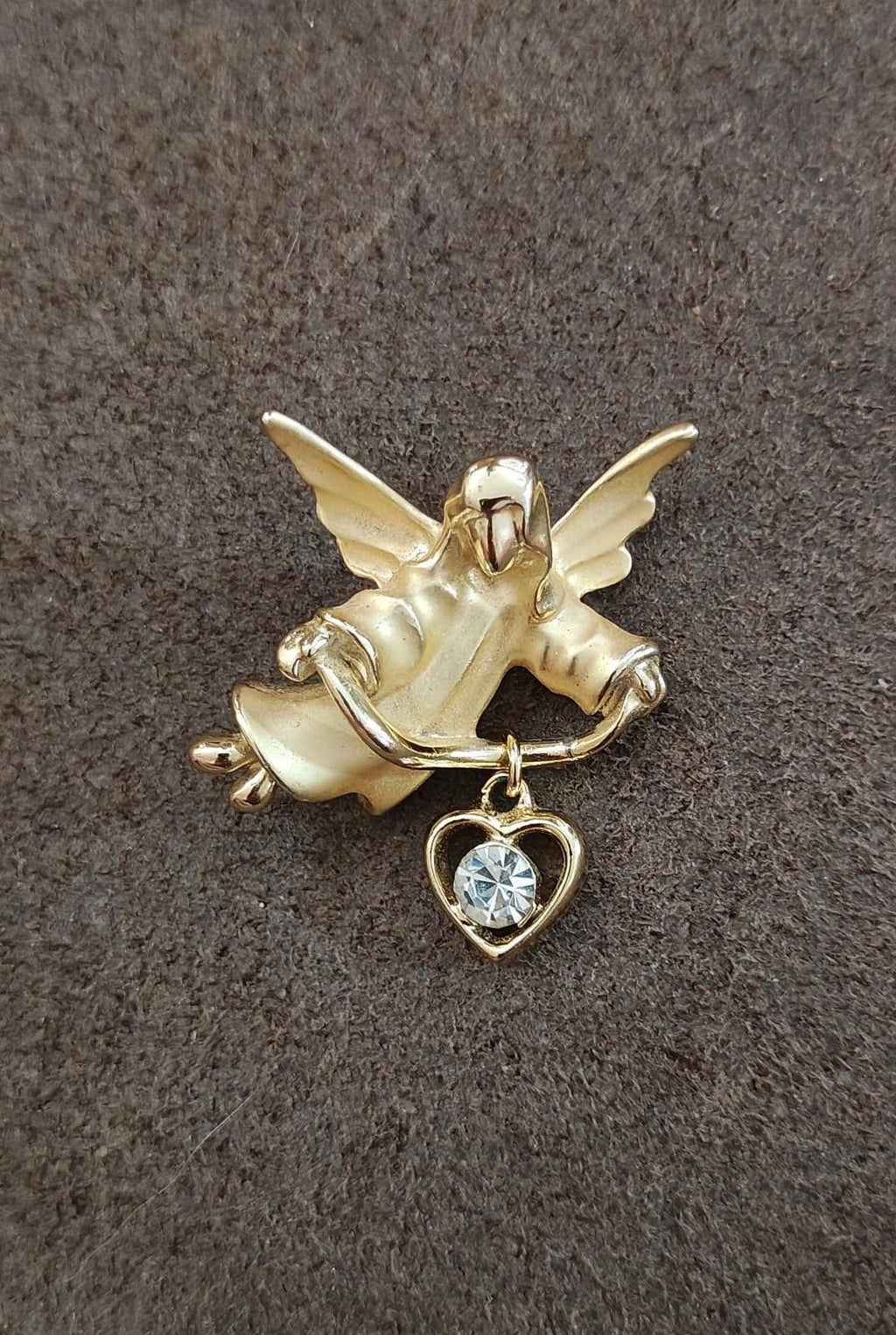 Gold-tone angel brooch pin featuring a heart-shaped charm with crystal stone