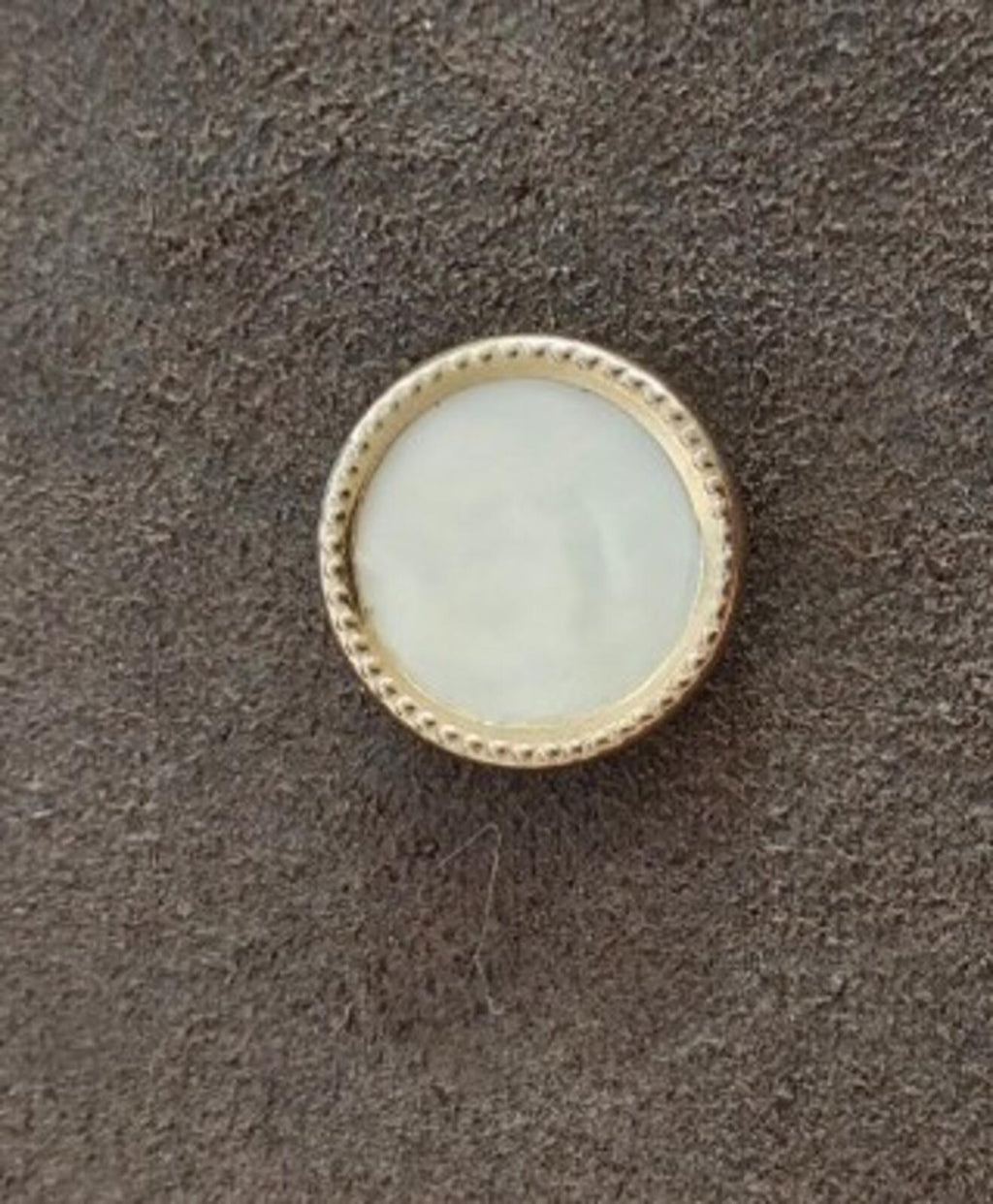 Small round mother-of-pearl brooch with gold-tone textured border