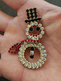 Gold-tone rhinestone snowman brooch with black, red and clear round stones on frame