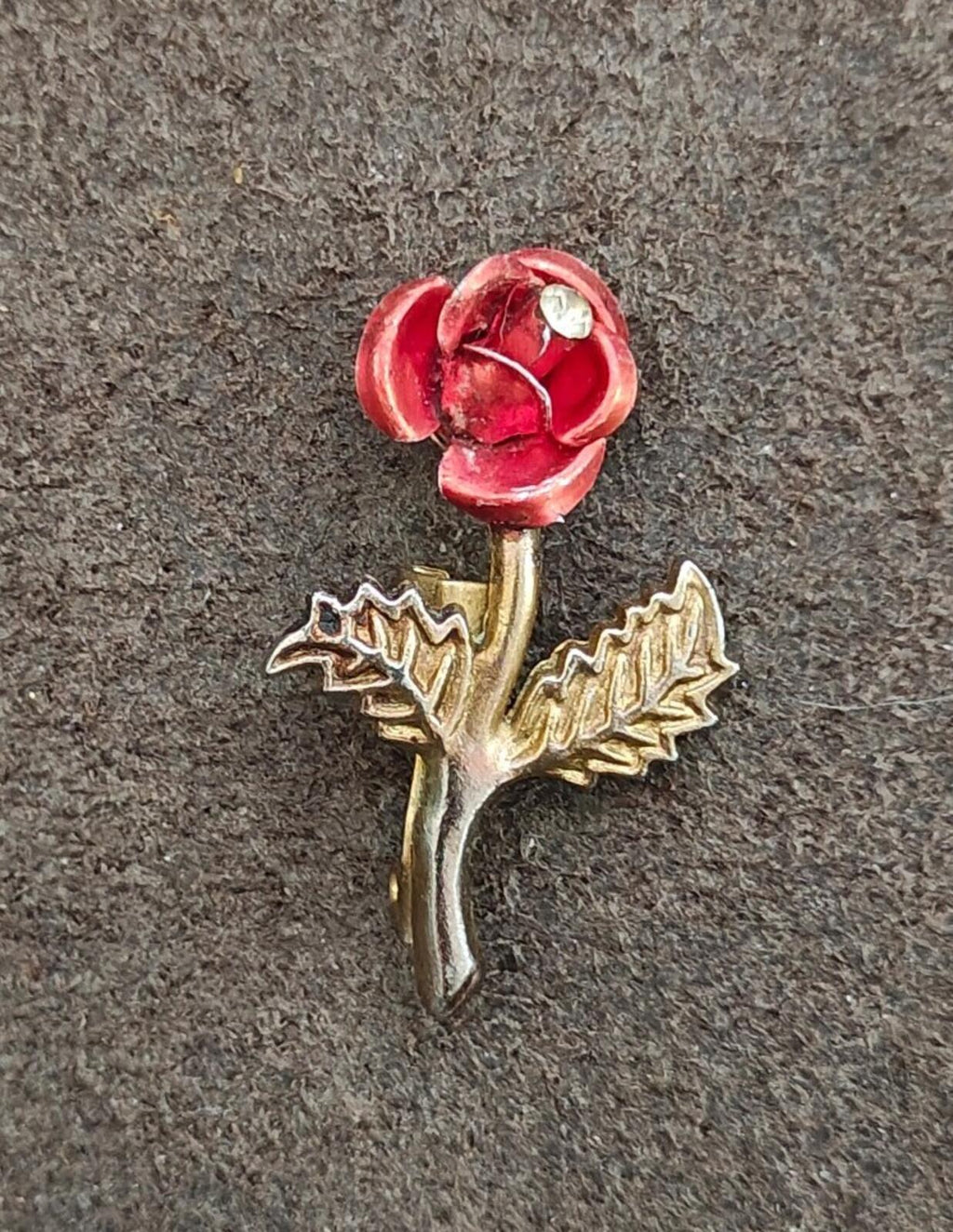 Red enamel rose brooch with gold-tone stem, side leaves, and clear rhinestone center
