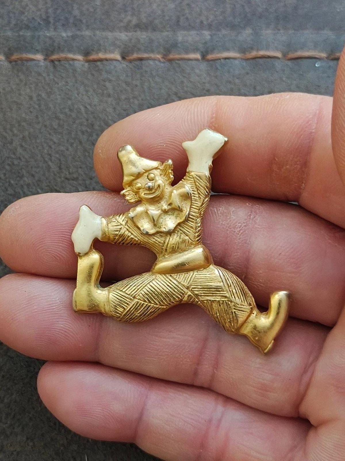 Gold tone clowning around enamel pendant with white face, raised arms, and stretched legs