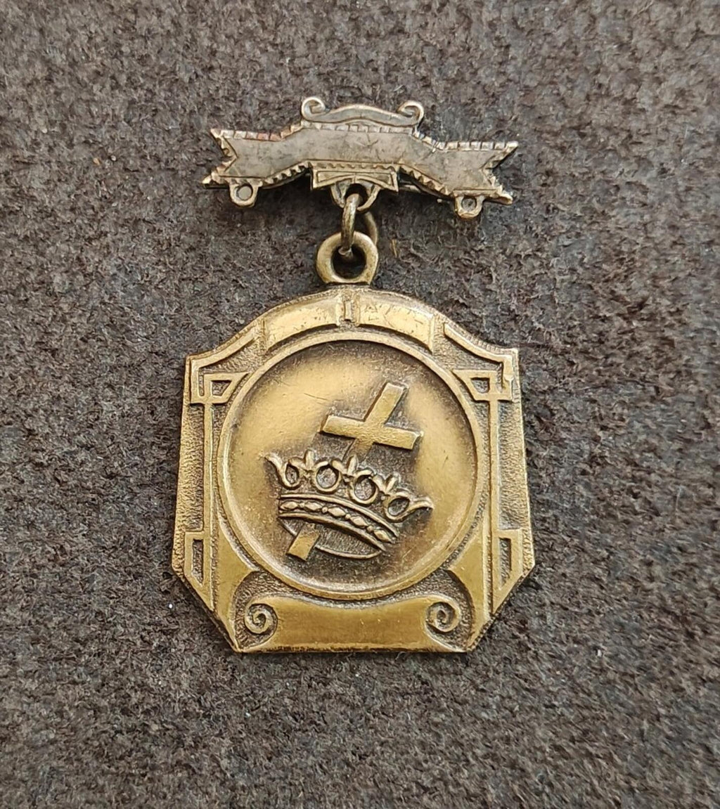 Gold medal pin on badge view with round cross-and-crown emblem and hanging ring bail.