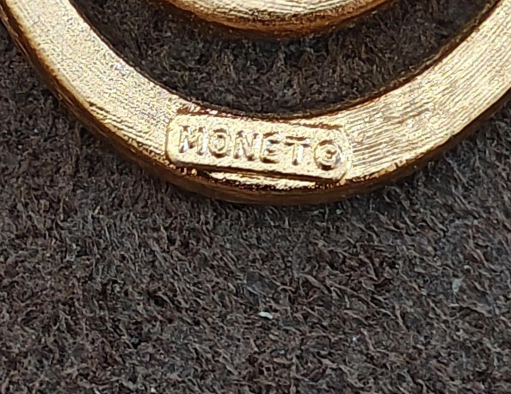 Monet signed gold tone brooch pin close-up on embossed signature on frame