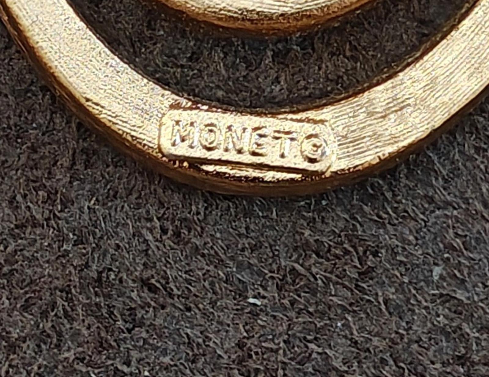 Monet signed gold tone brooch pin close-up on embossed signature on frame