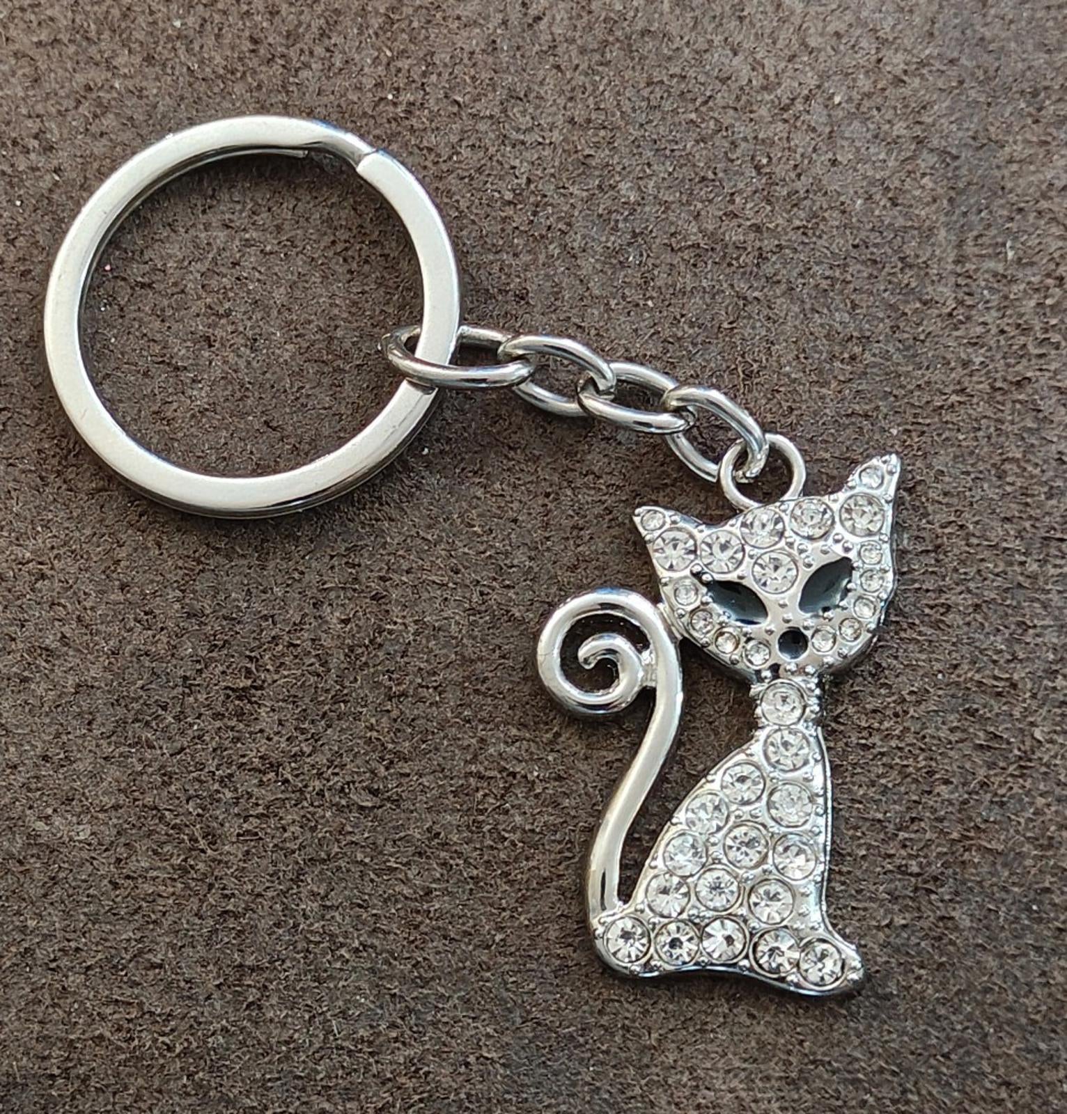 Silver keychain bag charm with rhinestone cat design and curled tail, chain links shown
