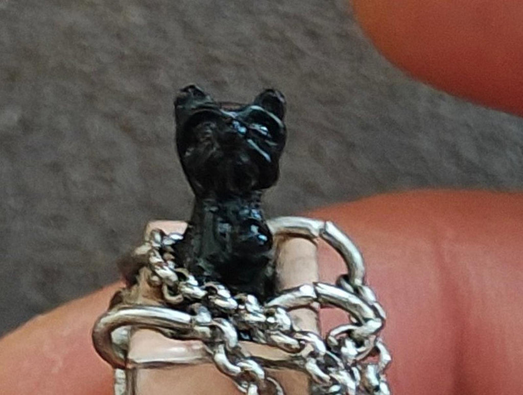 Juicy Couture bag charm close-up of black dog figure with silver chain links