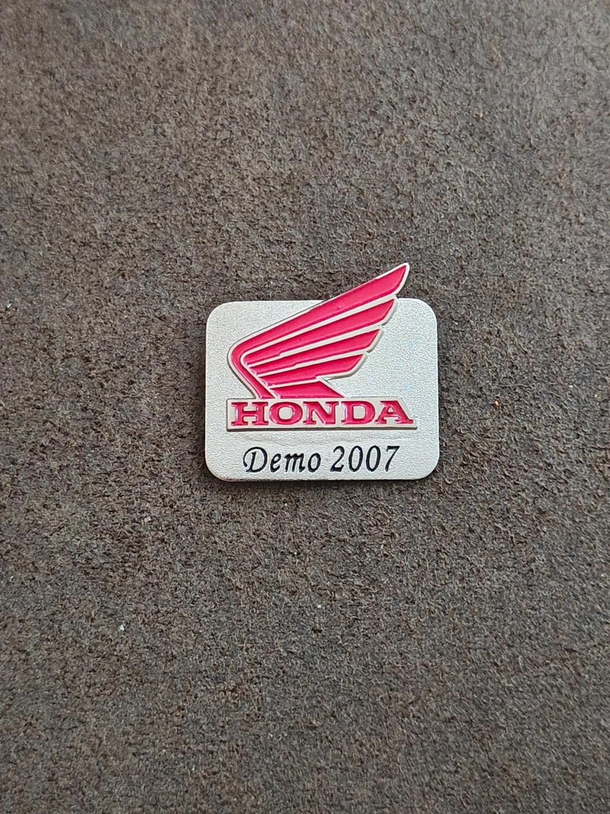 Silver-tone Honda Demo 2007 enamel pin on gray surface, red wing logo and text